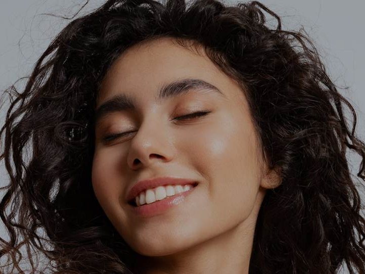 A woman smiling with her eyes comfortably closed
