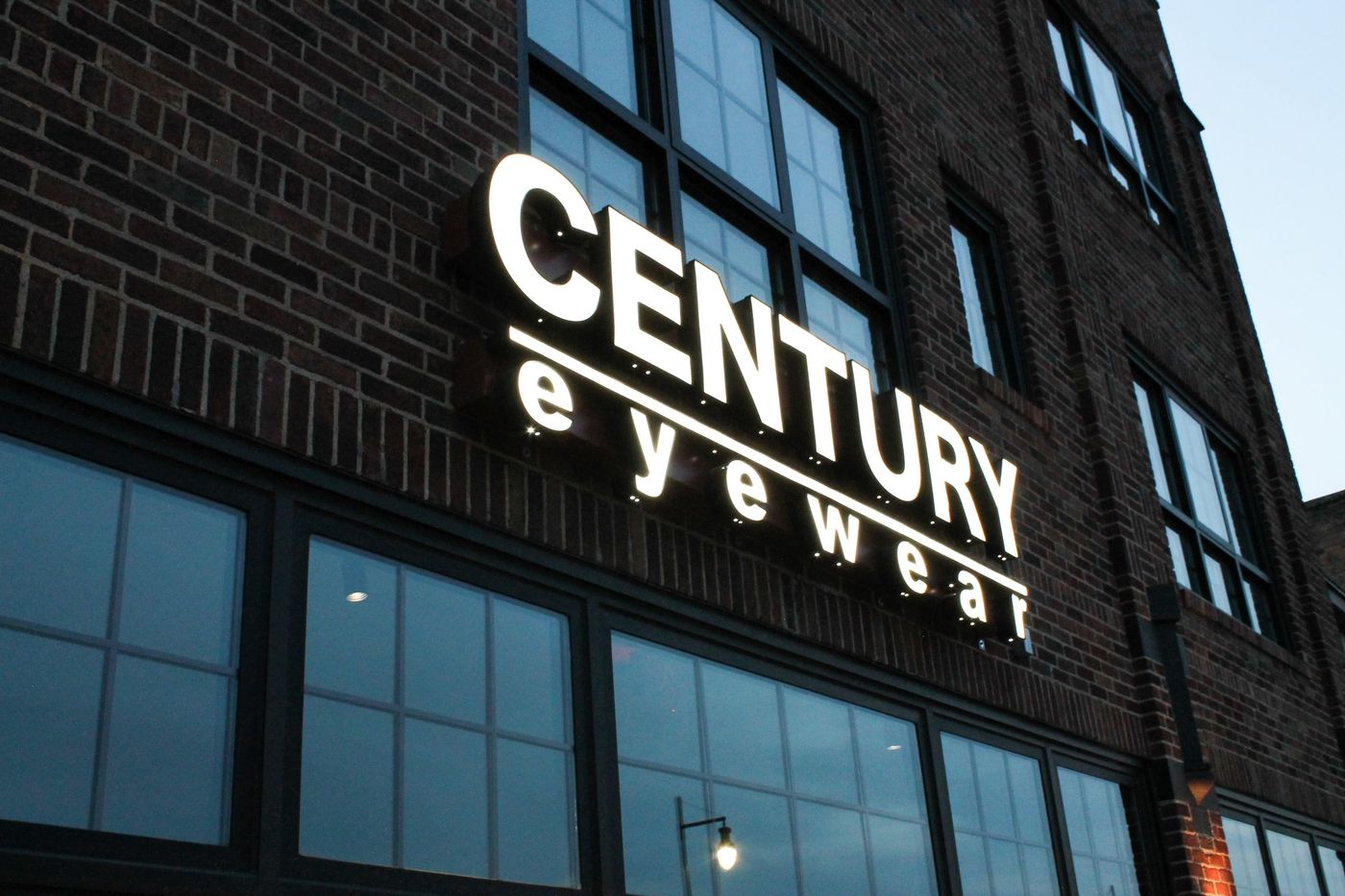 The Century Eyewear storefront sign on a brick building in downtown Minot